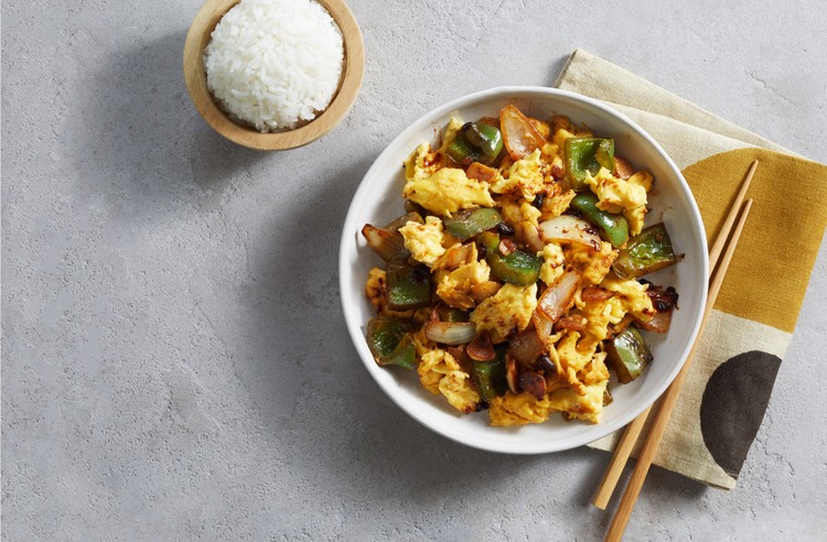 JUST Egg and vegetable stir-fry bowl with a side of rice and chopsticks