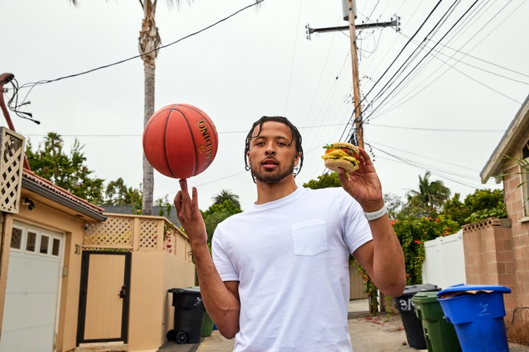 Cade Cunningham holds a JUST Egg sandwich and spins a basketball on the other hand.