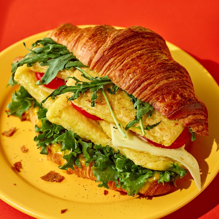 Croissant sandwich made with JUST Egg on a yellow plate